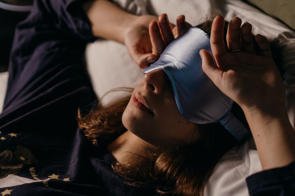 Mulher deitada com uma máscara de dormir sobre os olhos